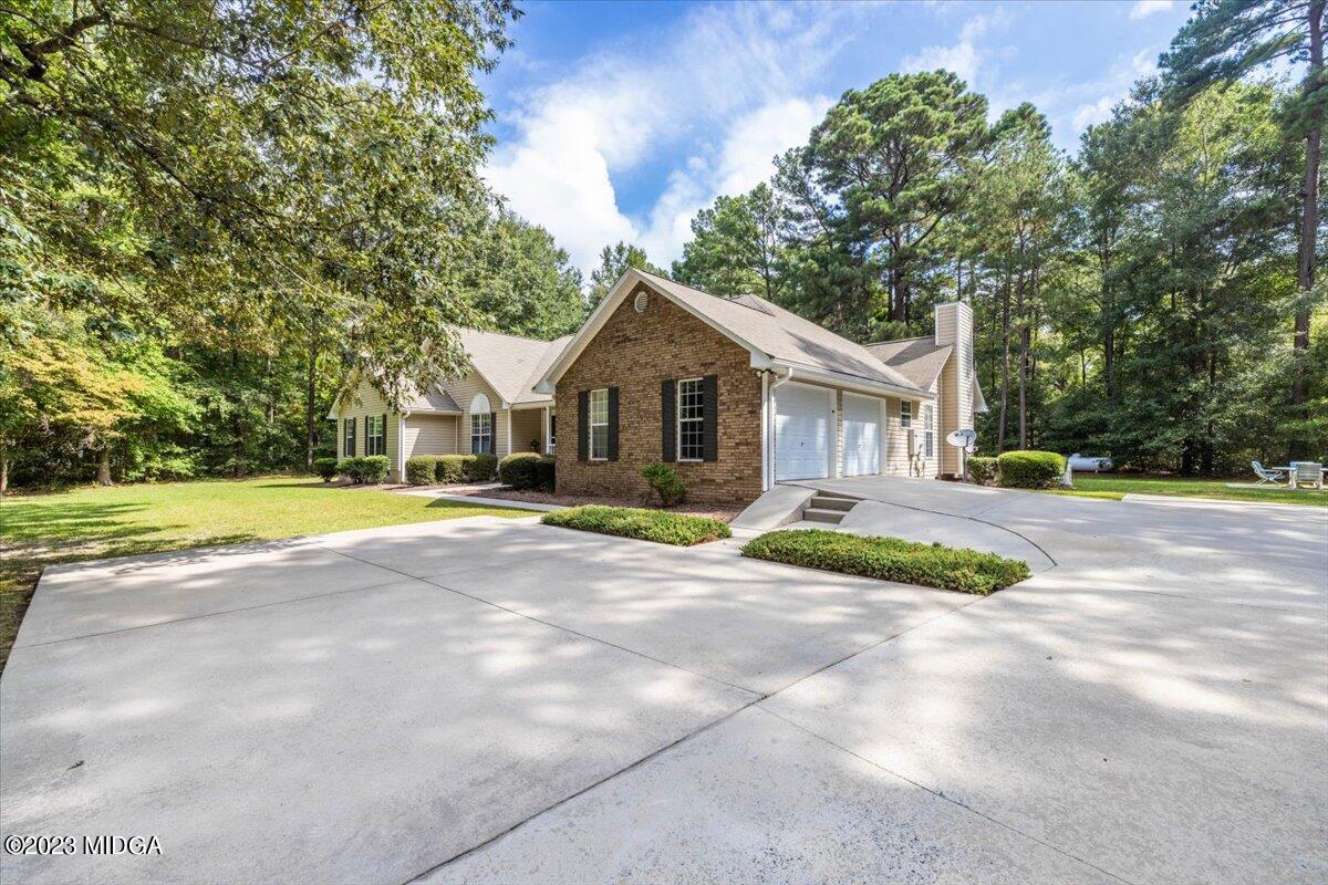 239 Altman Road Gray, GA 31032 - Photo 2 of 46 a view of a house with a big yard and large trees