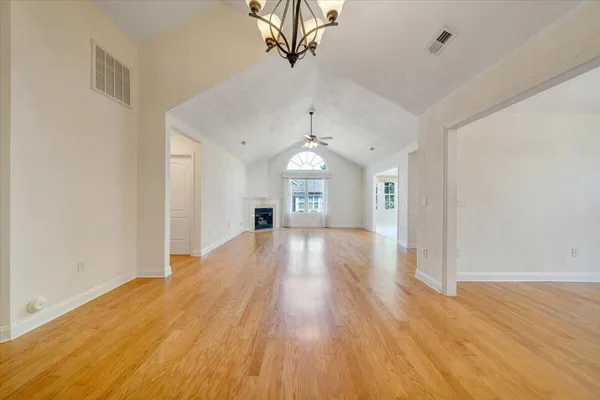 a view of a big room with wooden floor and a ceiling fan
