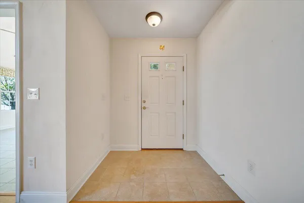 an empty room with wooden floor fireplace and windows