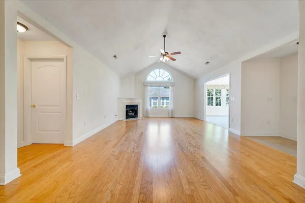 a view of an empty room with window and a ceiling fan