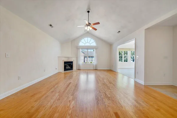 an empty room with a fireplace and fan