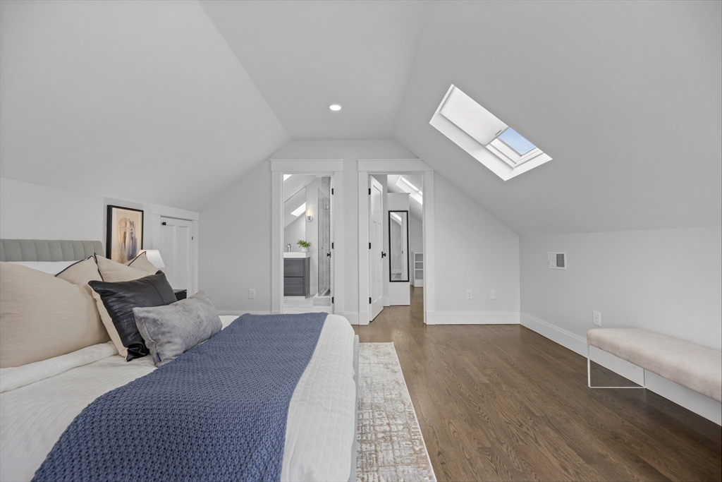 72 Governor Winthrop Road, Unit 2 Somerville, MA 02145 - Photo 12 of 27 a spacious bedroom with a bed and a chandelier