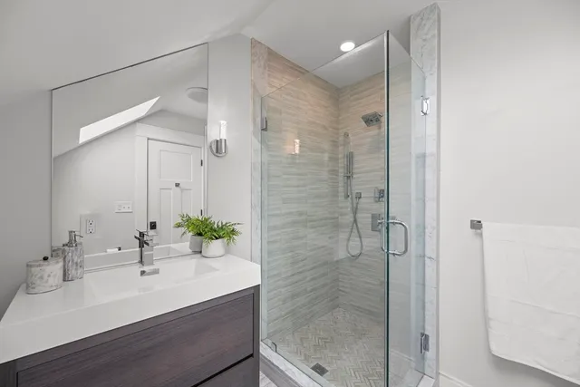 a bathroom with a sink shower and a mirror