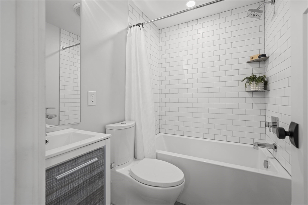 72 Governor Winthrop Road, Unit 2 Somerville, MA 02145 - Photo 21 of 27 a bathroom with a sink a toilet and a bathtub