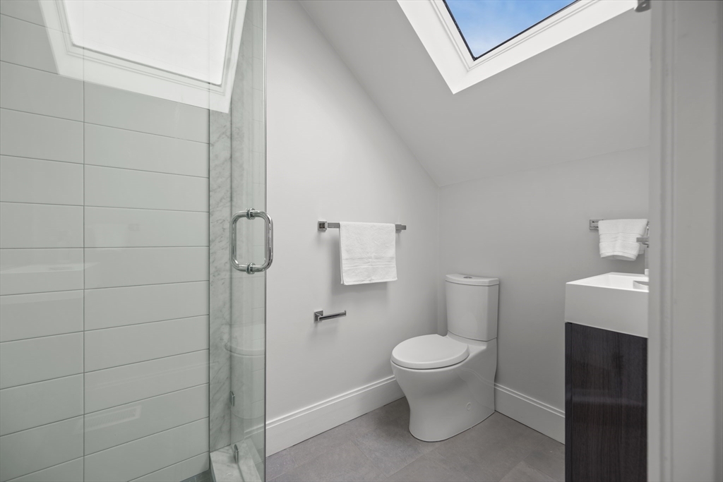 72 Governor Winthrop Road, Unit 2 Somerville, MA 02145 - Photo 24 of 27 a white toilet sitting next to a bathroom sink