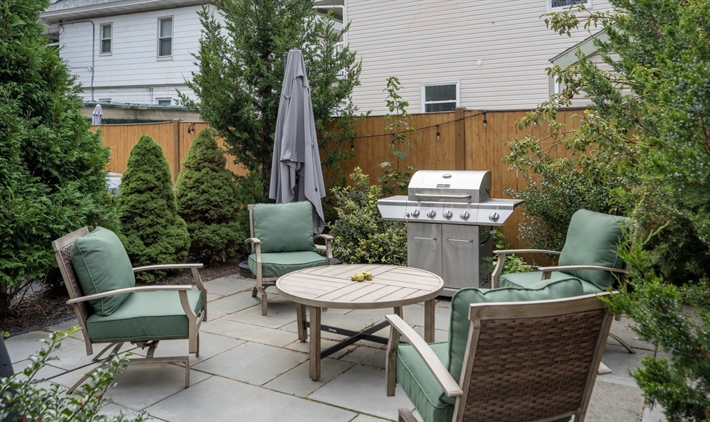72 Governor Winthrop Road, Unit 2 Somerville, MA 02145 - Photo 27 of 27 a view of a table and chairs in back yard of a house