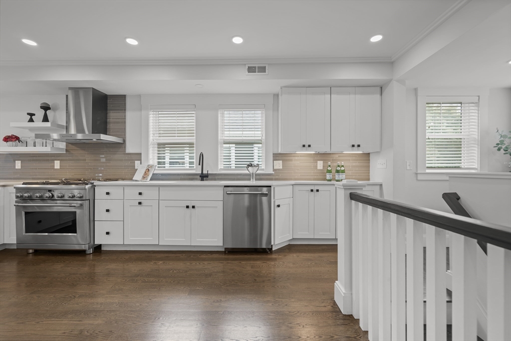 72 Governor Winthrop Road, Unit 2 Somerville, MA 02145 - Photo 9 of 27 a kitchen with stainless steel appliances granite countertop a stove a sink and white cabinets