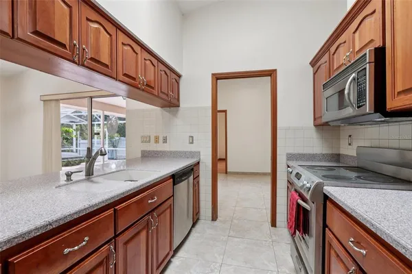 a kitchen with stainless steel appliances granite countertop a sink a stove and a wooden floors