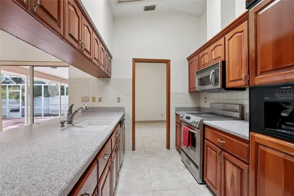 a kitchen with stainless steel appliances granite countertop a sink a stove and cabinets