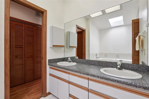 a bathroom with a granite countertop sink and a mirror
