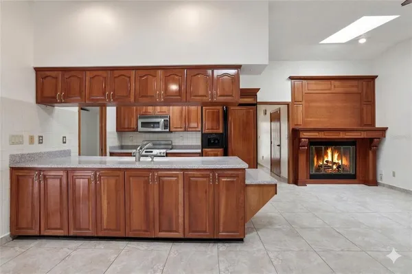 a open kitchen with cabinets and fireplace