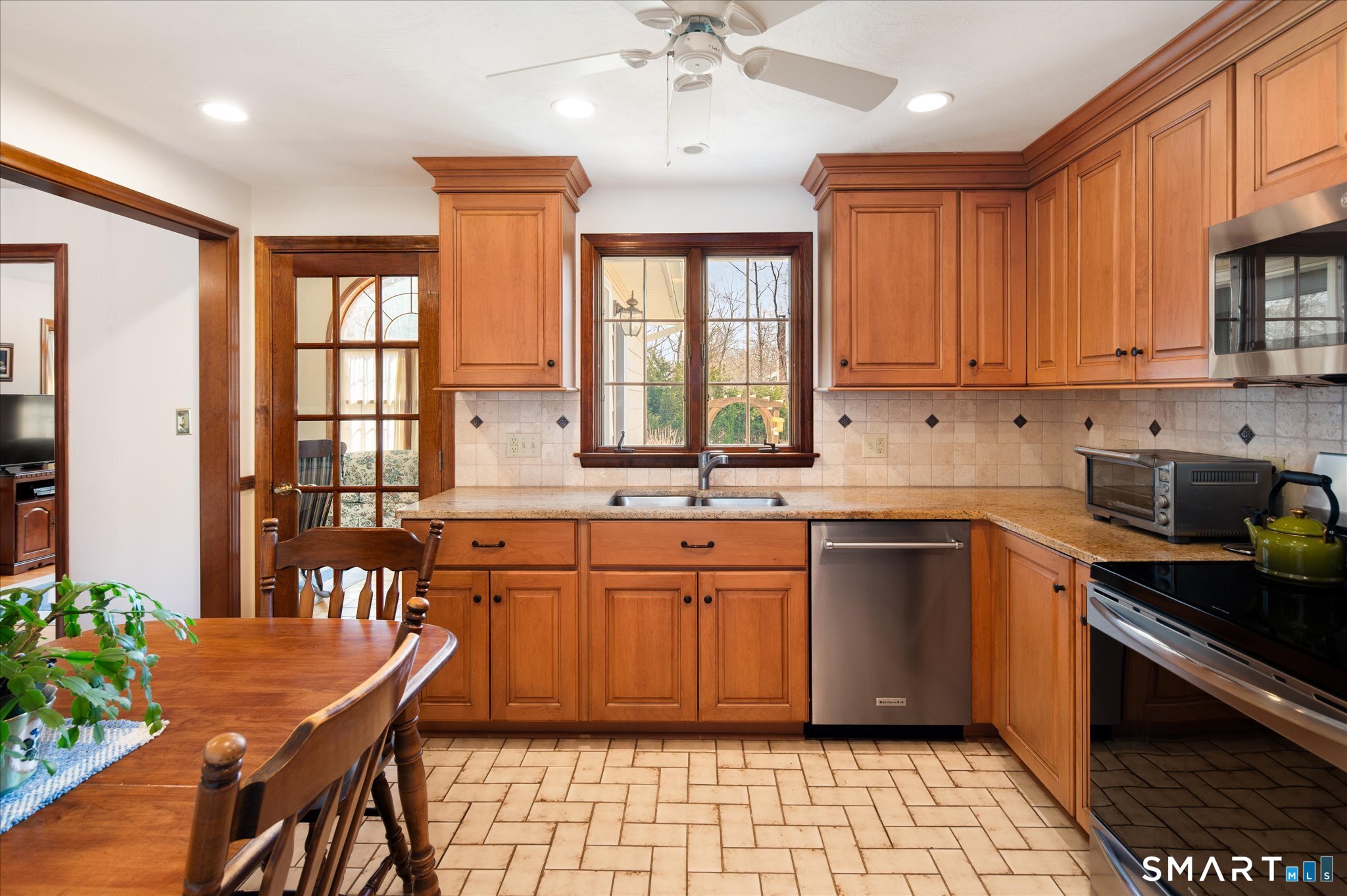 100 Bette Circle Vernon, CT 06066 - Photo 8 of 32 a kitchen with stainless steel appliances granite countertop a stove top oven a sink dishwasher a dining table and chairs with wooden floor