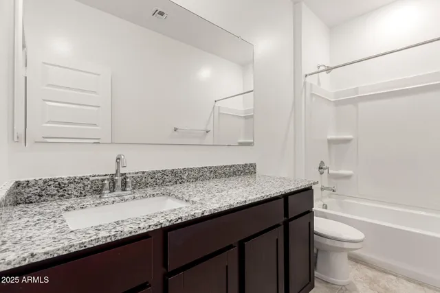 a bathroom with a granite countertop sink a toilet and a bathtub