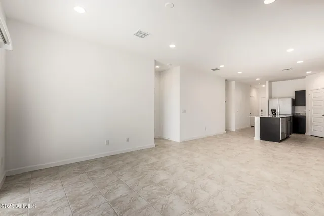 a view of a big room with stainless steel appliances wooden floor and windows