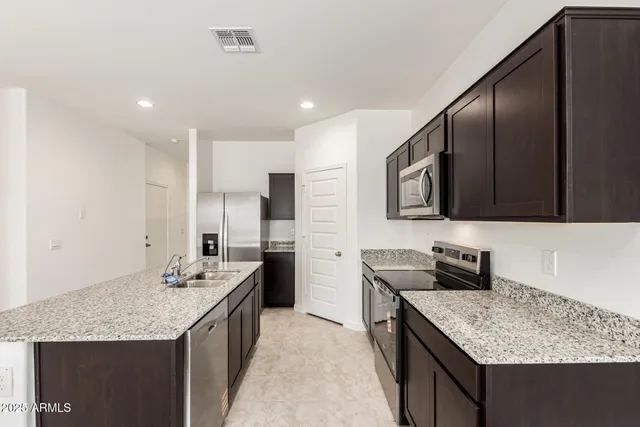 a kitchen with stainless steel appliances granite countertop a sink stove and refrigerator