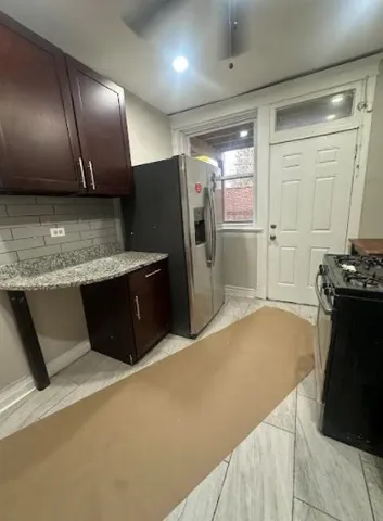 a kitchen with stainless steel appliances granite countertop a refrigerator and a stove