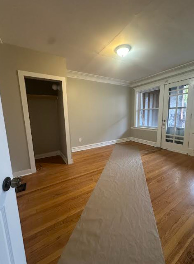 7704 South Aberdeen Street, Unit 1S Chicago, IL 60620 - Photo 7 of 14 an empty room with wooden floor and windows