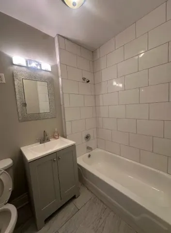 a bathroom with a bathtub a sink a toilet and a mirror