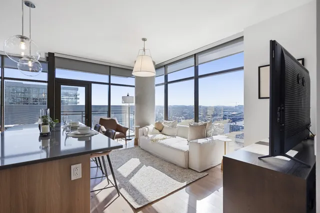 a kitchen with stainless steel appliances kitchen island granite countertop a stove top oven a sink a dining table and chairs with wooden floor