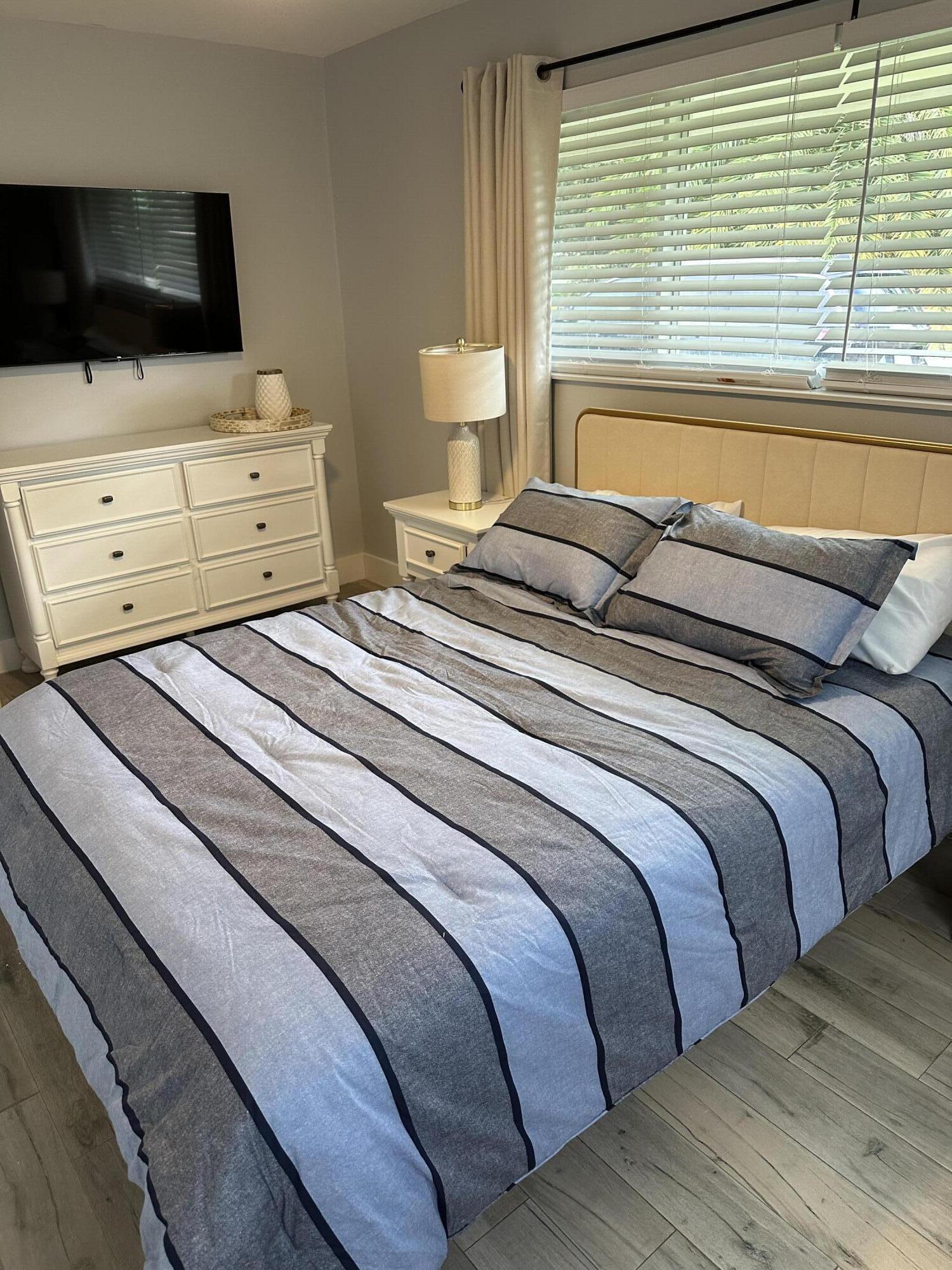 5111 Northeast 27th Terrace Lighthouse Point, FL 33064 - Photo 11 of 23 a bedroom with a bed and flat screen tv