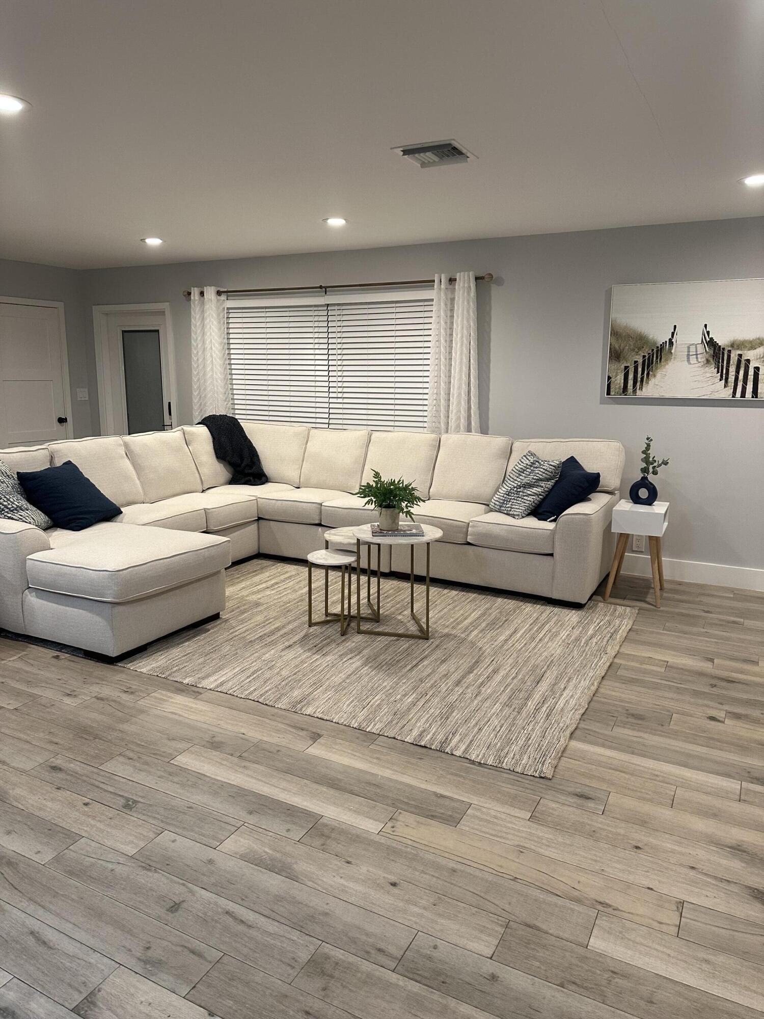 5111 Northeast 27th Terrace Lighthouse Point, FL 33064 - Photo 14 of 23 a living room with couches and kitchen view with wooden floor
