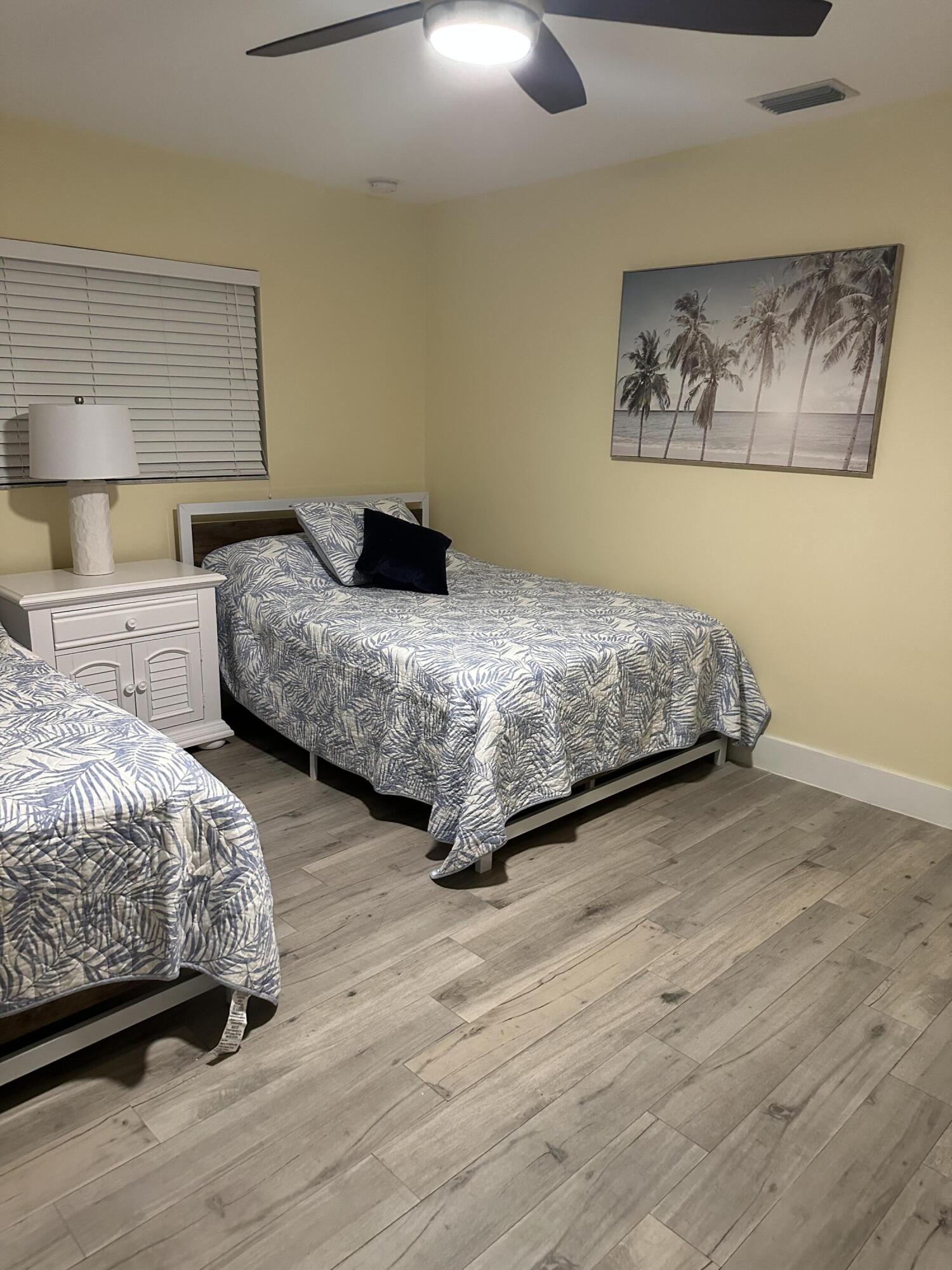 5111 Northeast 27th Terrace Lighthouse Point, FL 33064 - Photo 17 of 23 a bedroom with two beds and painting on the wall