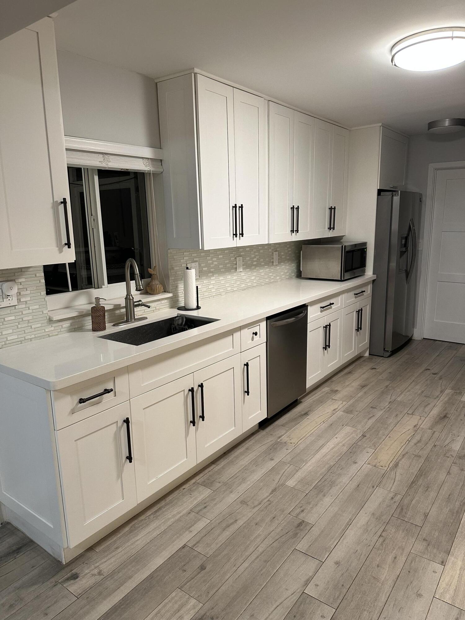 5111 Northeast 27th Terrace Lighthouse Point, FL 33064 - Photo 20 of 23 a kitchen with white cabinets and sink
