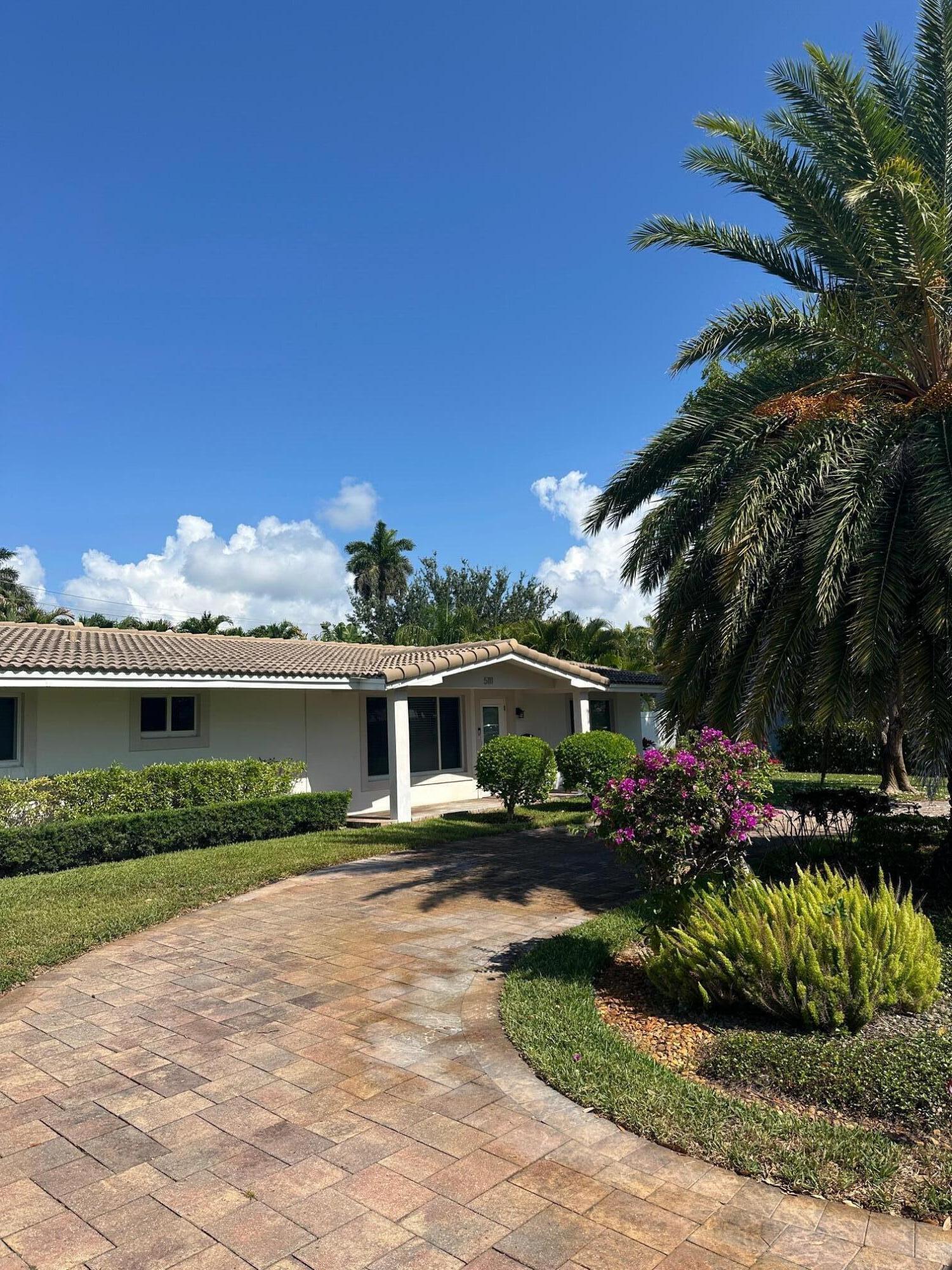 5111 Northeast 27th Terrace Lighthouse Point, FL 33064 - Photo 22 of 23 a front view of a house with a yard