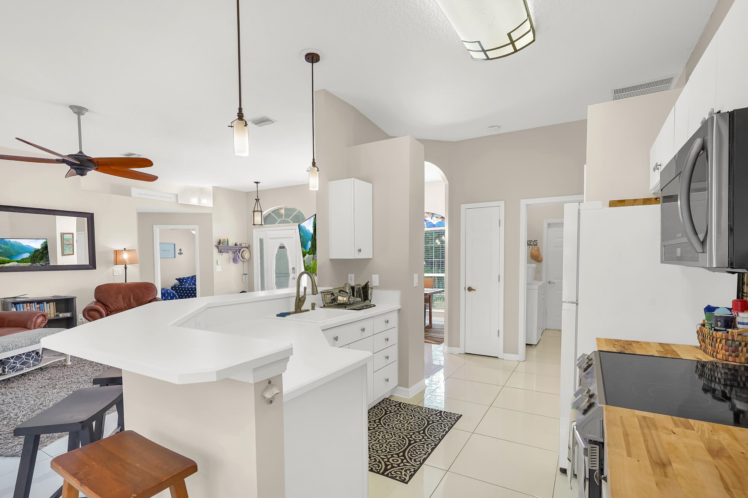 308 A Street St. Augustine, FL 32080 - Photo 24 of 46 a kitchen with stainless steel appliances kitchen island granite countertop a table chairs in it and white cabinets