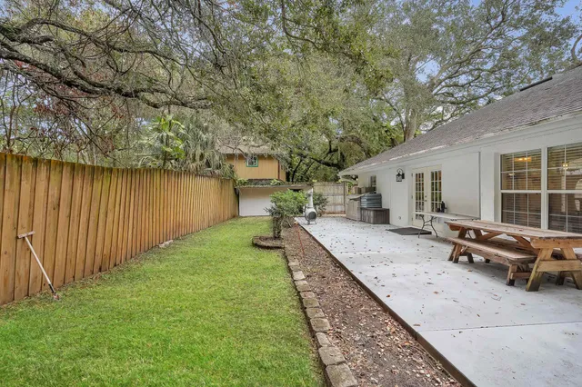 a view of a backyard with sitting area and tree