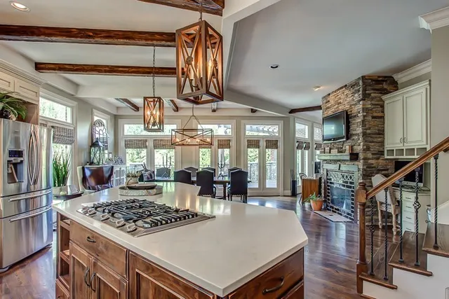 a kitchen with a stove and a view of living room