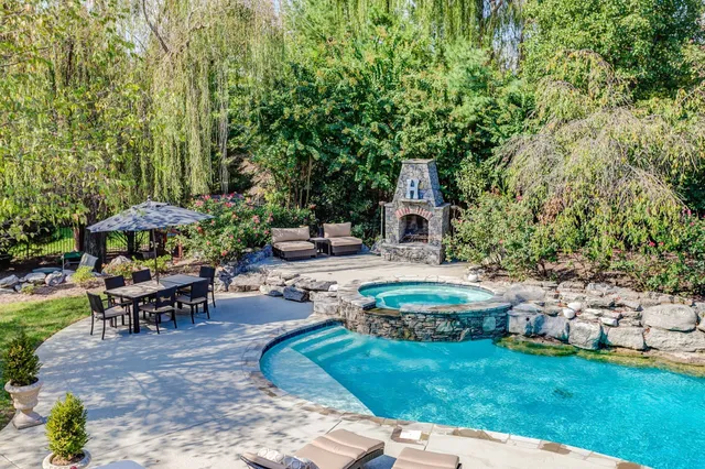 a view of a house with swimming pool and sitting area