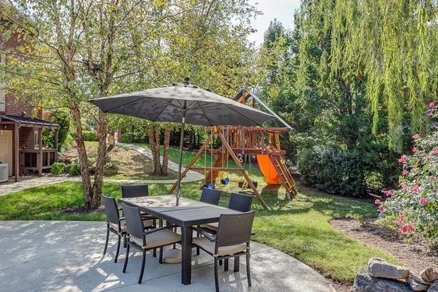 a view of a backyard with chairs and potted plants