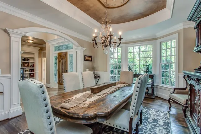 a dining room with furniture a chandelier and wooden floor
