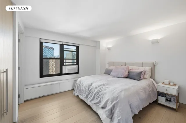 a large bed sitting in a bedroom next to a window