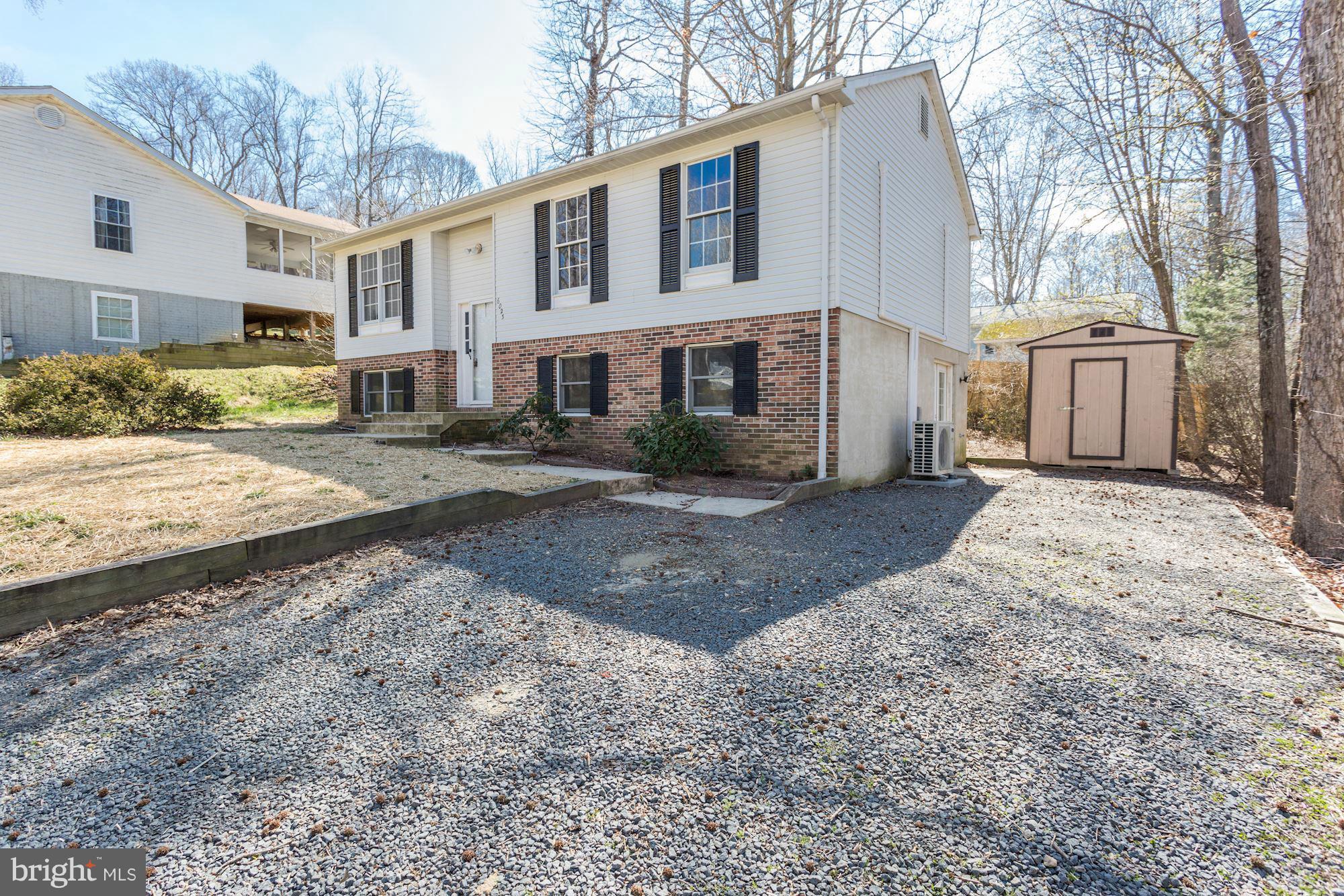 6023 Maple Road St. Leonard, MD 20685 - Photo 2 of 30 a front view of a house with a yard and garage