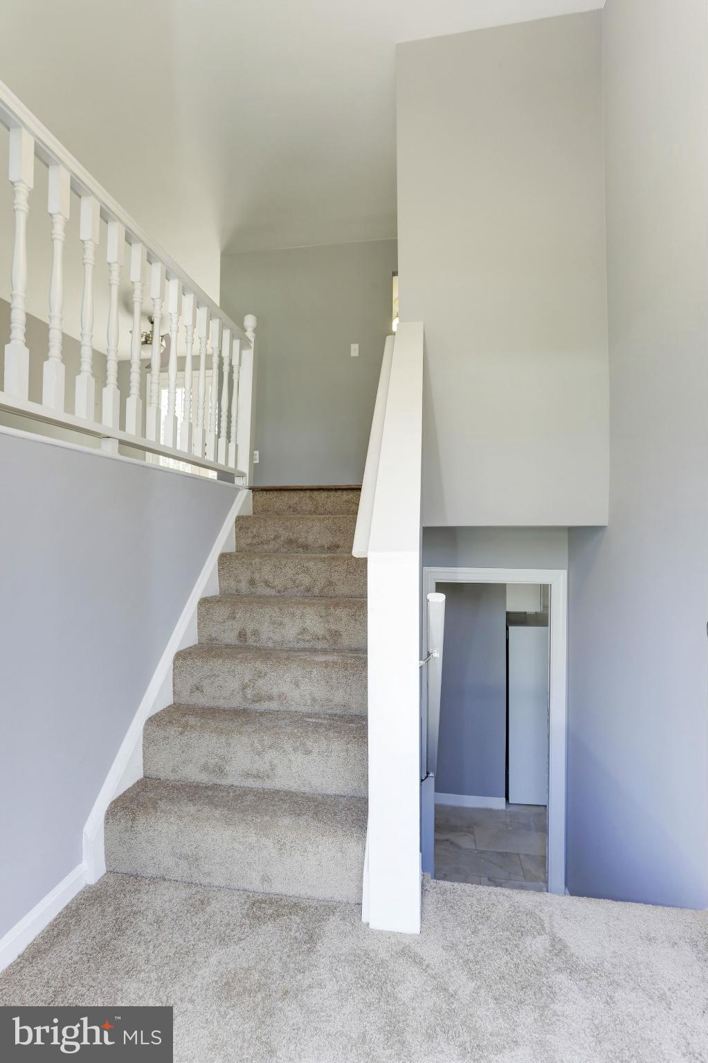 6023 Maple Road St. Leonard, MD 20685 - Photo 16 of 30 a view of staircase with lots of frames on wall and a potted plant