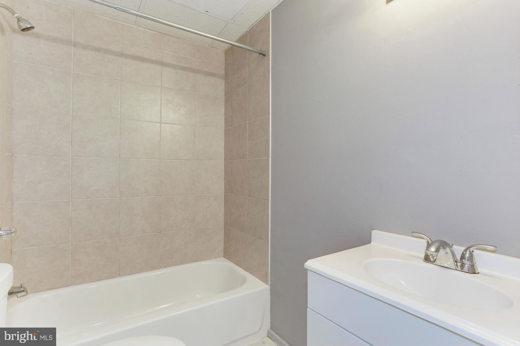 6023 Maple Road St. Leonard, MD 20685 - Photo 23 of 30 a white bath tub sitting next to a white sink and vanity