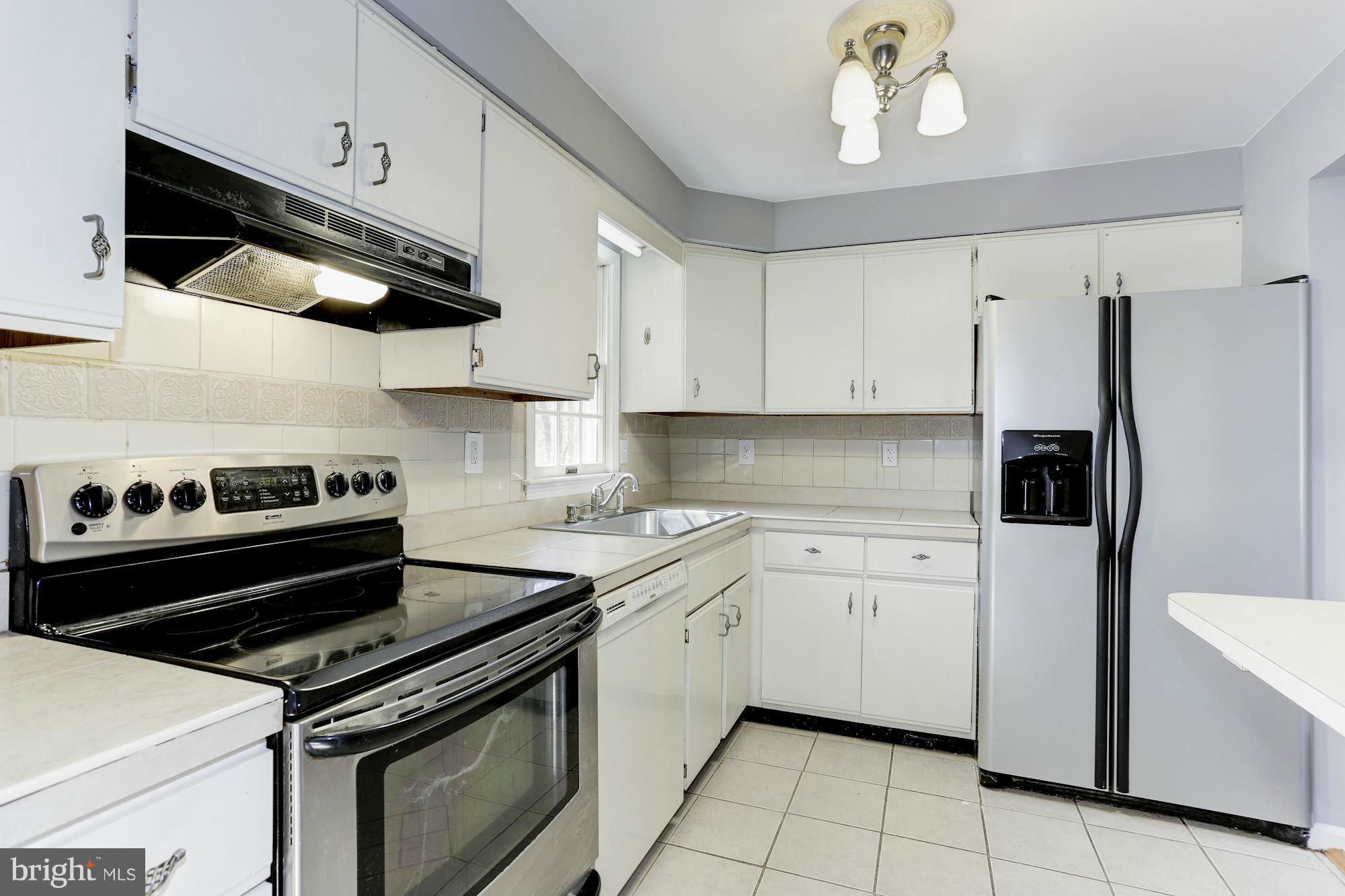 6023 Maple Road St. Leonard, MD 20685 - Photo 8 of 30 a kitchen with a stove microwave and cabinets