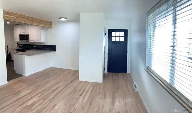 a view of kitchen and hallway with wooden floor
