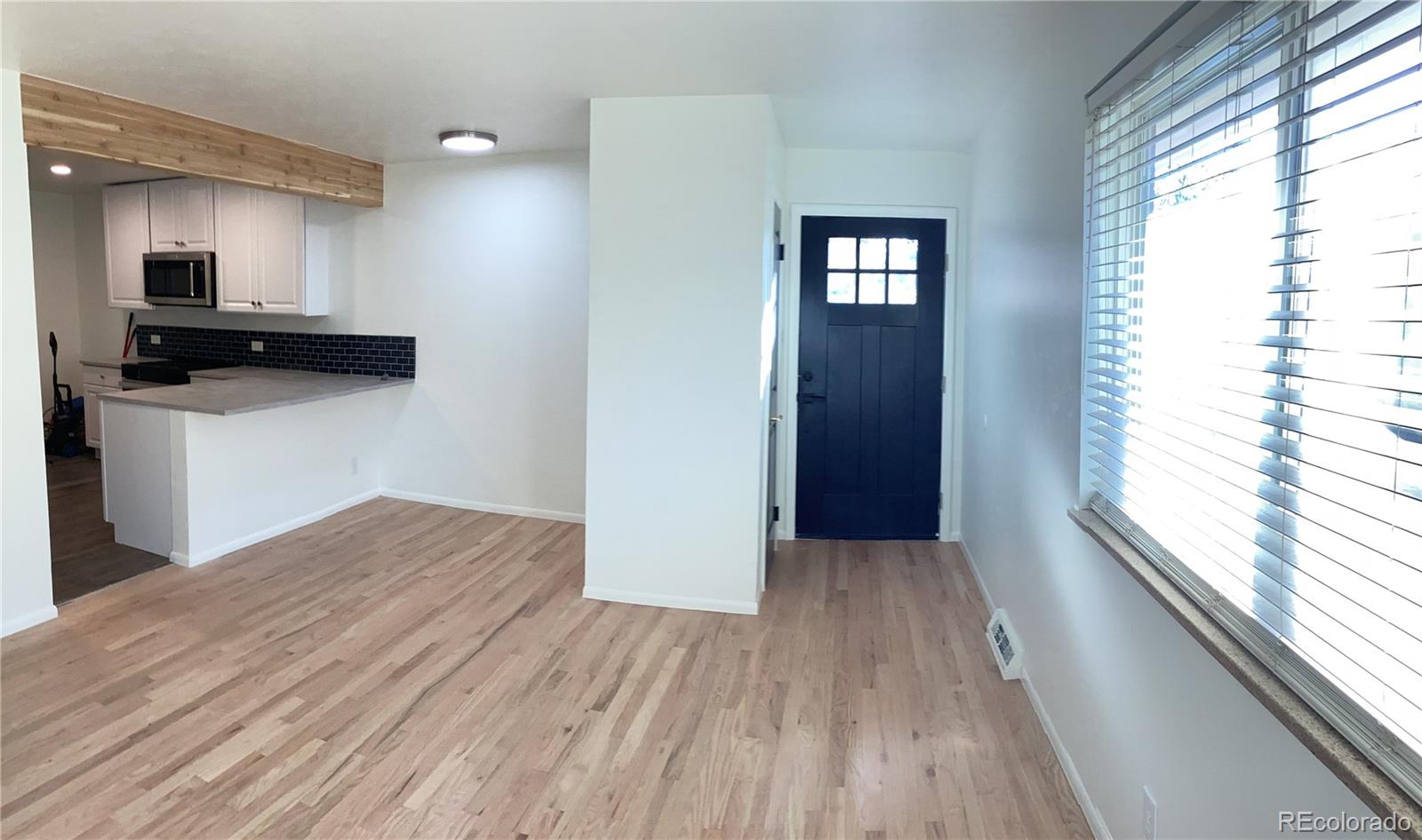 2463 South Corona Street Denver, CO 80210 - Photo 2 of 10 a view of kitchen and hallway with wooden floor