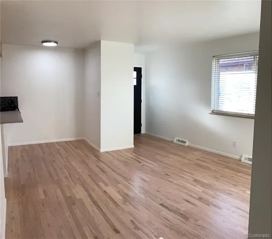 a view of empty room with wooden floor