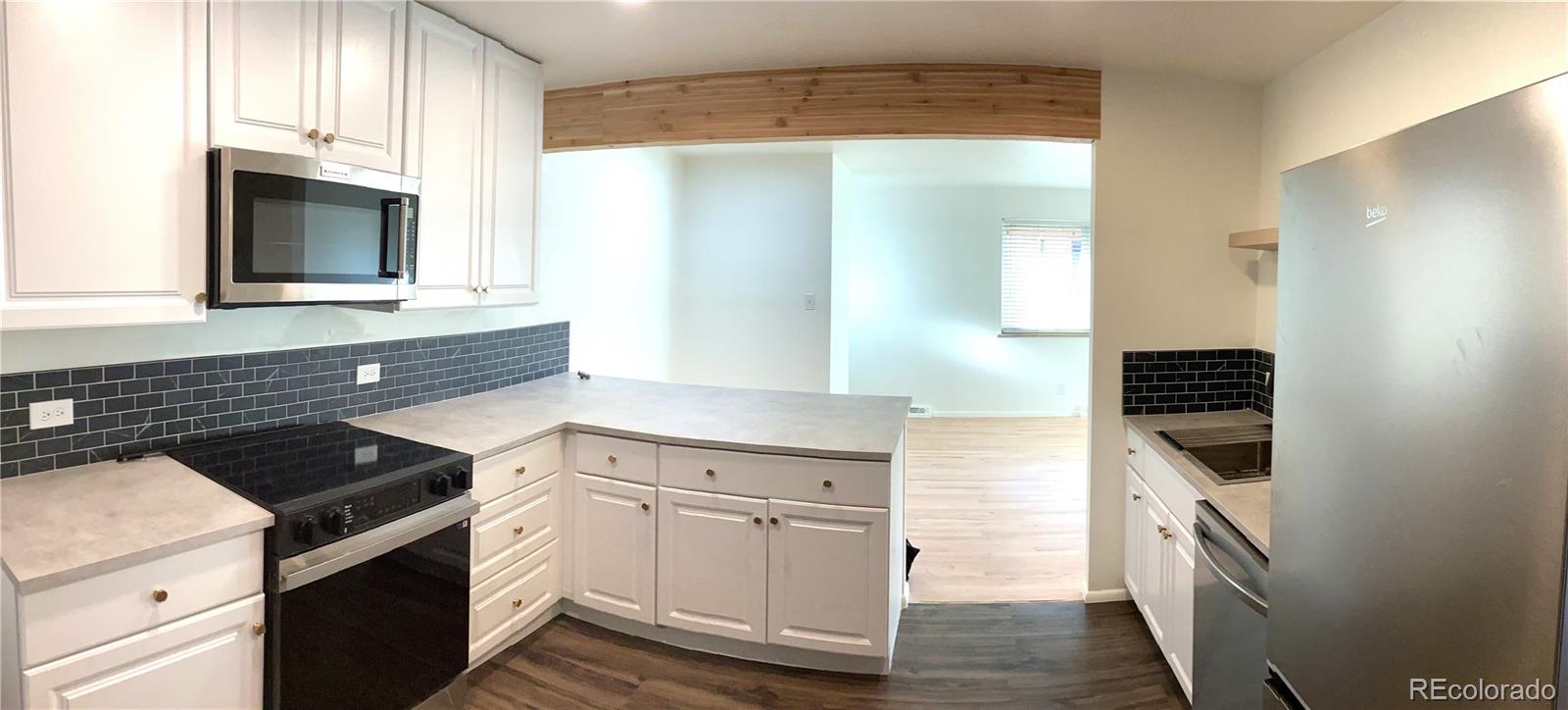 2463 South Corona Street Denver, CO 80210 - Photo 4 of 10 a kitchen with white cabinets and appliances