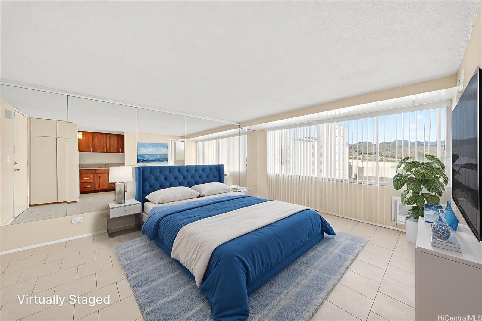 a bedroom with a large bed and a potted plant