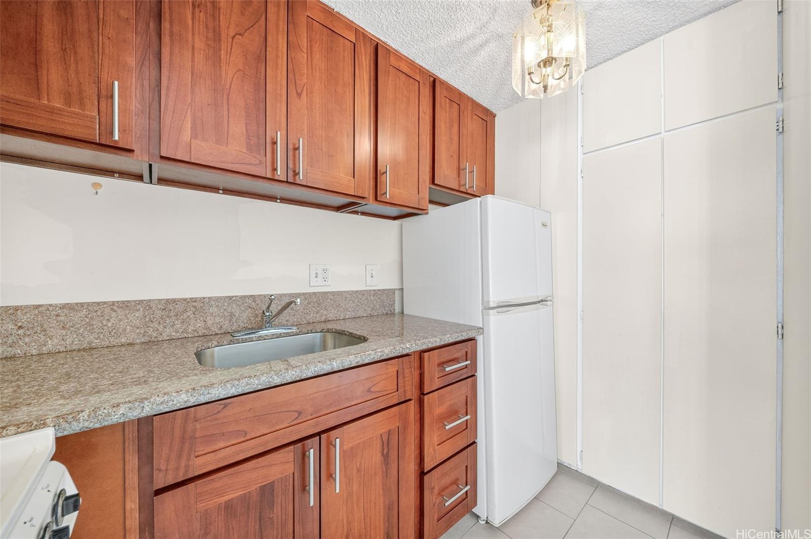 2888 Ala Ilima Street, Unit 1512 Honolulu, HI 96818 - Photo 12 of 25 a kitchen with stainless steel appliances granite countertop a sink a refrigerator and cabinets