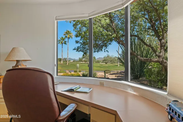 a view of a workspace with furniture and a window