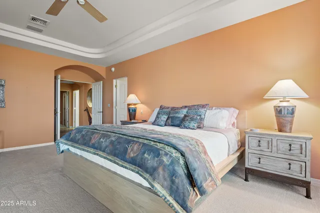 a bedroom with a large bed and a chandelier