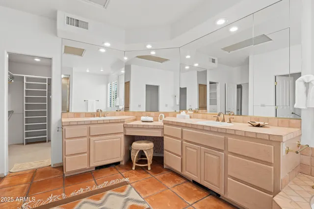 a large bathroom with a double vanity sink a mirror and a bathtub