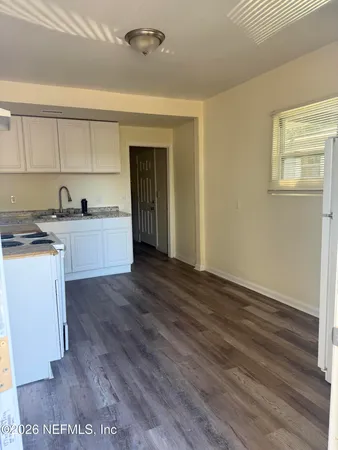 a kitchen with a sink and wooden floor