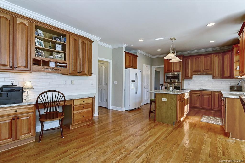 3203 Planters Ridge Road Charlotte, NC 28270 - Photo 4 of 36 a kitchen with stainless steel appliances granite countertop a refrigerator a stove a sink a dining table and chairs with wooden floor
